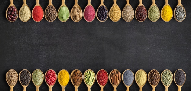 Spices and herbs in wooden spoons. Collection of spices with an empty space for an inscription or label.