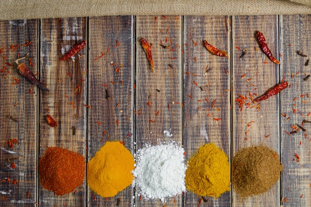 Spices near chili on wood