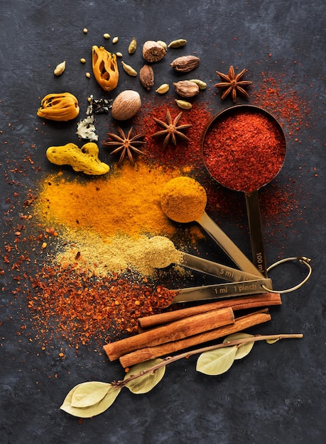 Spices and seasonings in measuring spoons and on a table