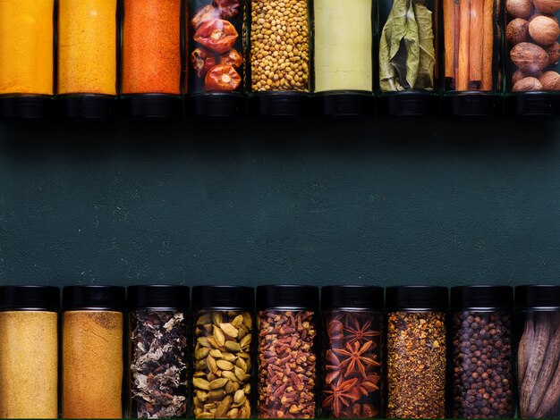 Spices and spicy banner Colorful various spices in glass jars copy space top view