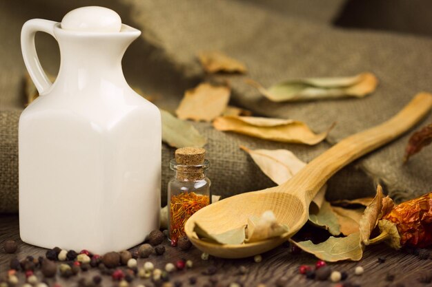 Spices in the spoon with jar of olive oil