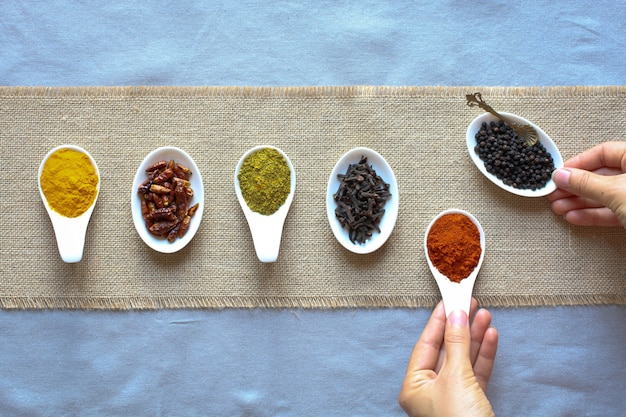 Spices in the spoons over a black stone 