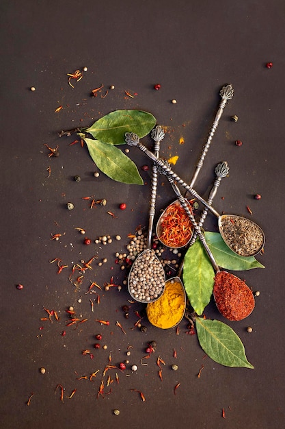 Spices in spoons on a brown background closeup