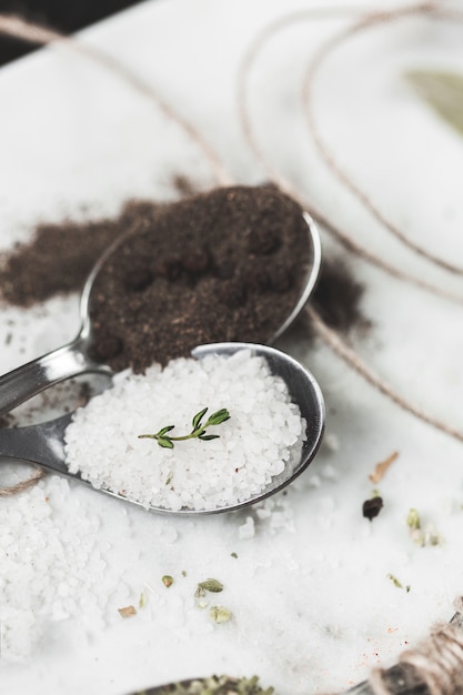 Spices in spoons.  of salt and pepper. Stone marble table . Rustic vintage color toning