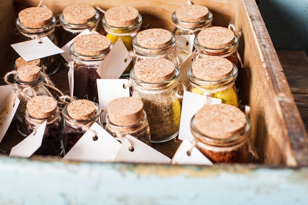 Spices in vintage bottles inside rustic box shelf