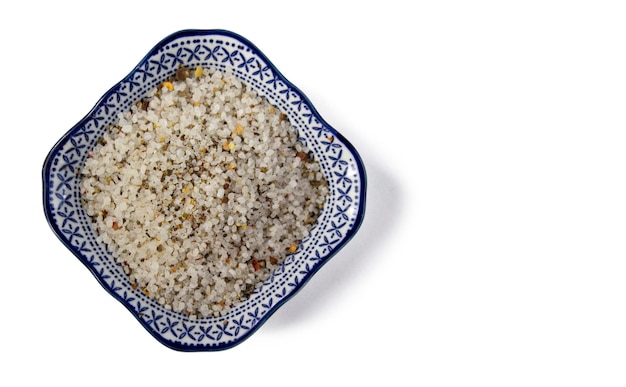 Spices white black and red peppers sea salt on ornamental plate on a white background closeup isolated