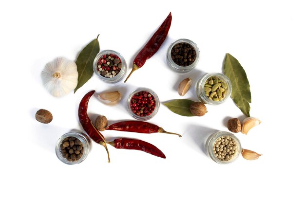 Spices white black and red peppers sea salt sprinkled garlic and chilli on a white background closeup