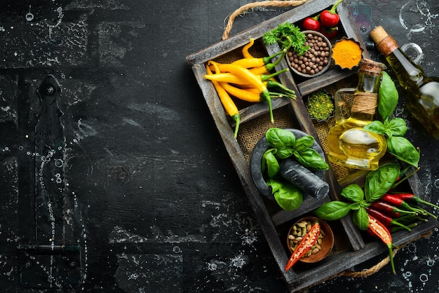 Spices in a wooden box basil pepper oil paprika herbs Food background Top view