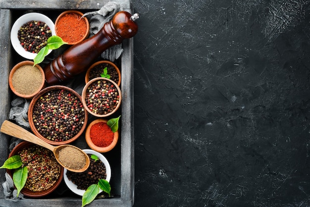 Spices in a wooden box. Colored pepper, sea salt, ground pepper, chili pepper. Top view.