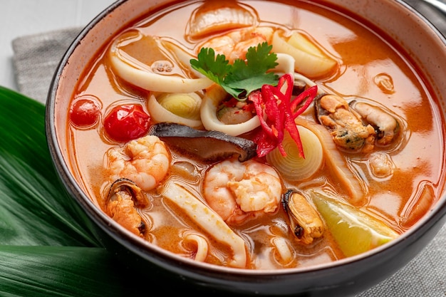새우 오징어 홍합과 야채 아시아 요리를 곁들인 매콤한 아시아 똠얌 수프