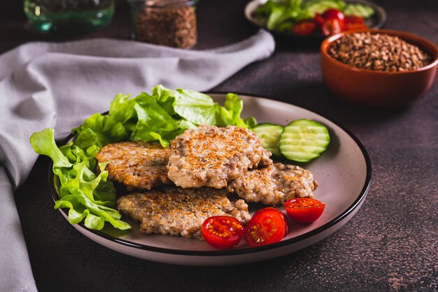 Spicy buckwheat pancakes with slices of cucumber tomato and lettuce on a plate