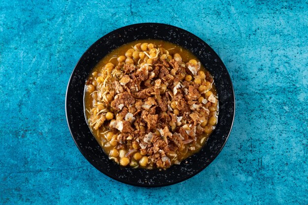 Spicy chana chat masala chotpoti in a black dish isolated on\
background top view of indian bangali and pakistani food chat pata\
food