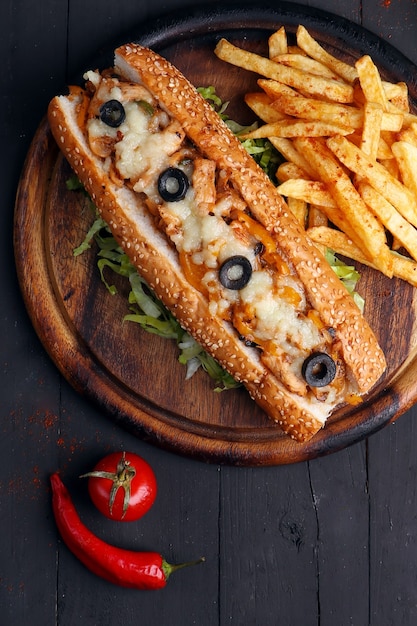 Spicy chicken sandwich on black wooden background