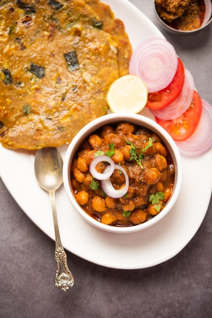 Spicy chickpea masala or chole curry with Pyaj Paratha or Spring Onion Parantha and mango pickle