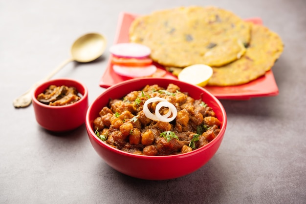 Photo spicy chickpea masala or chole curry with pyaj paratha or spring onion parantha and mango pickle