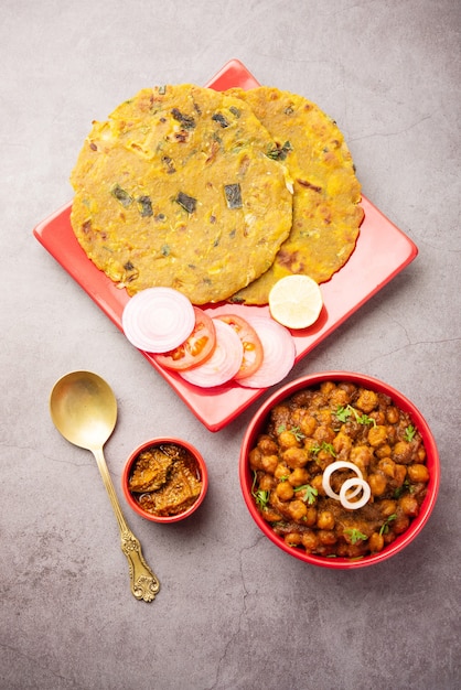 Photo spicy chickpea masala or chole curry with pyaj paratha or spring onion parantha and mango pickle