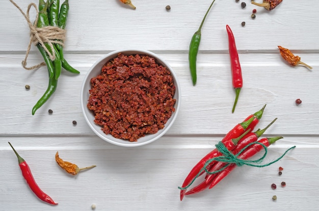 Photo spicy chili on a light table, flatlay. used as an ingredient for harissa, ajika, muhammara. east and middle east kitchen.