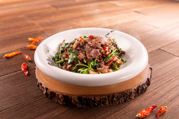 Spicy chilli Stirfried beef with parsley served dish isolated on wooden table top view of Hong Kong food