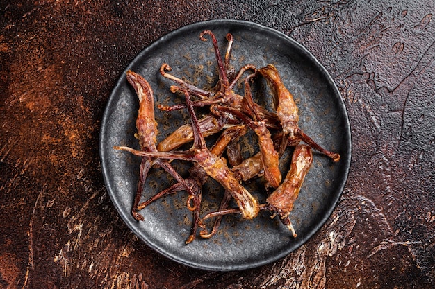 Spicy Dip fried duck tongue Dark background Top view