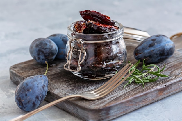 Spicy dried plums in a glass jar