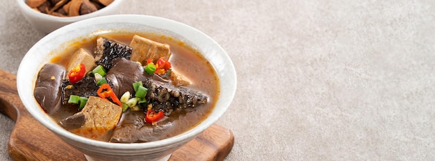 Spicy duck blood jelly soup and stinky tofu with scallion and chili pepper topping