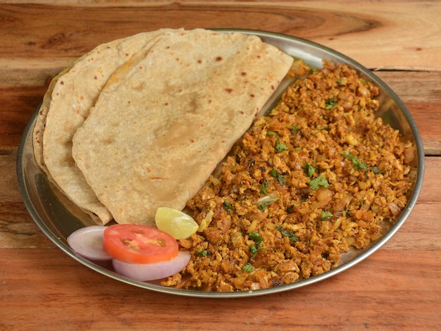 Spicy Egg bhurji or anda bhurji with Chapati Scrambled egg with Indian flat bread Protein rich breakfast food served over a rustic wooden table selective focus