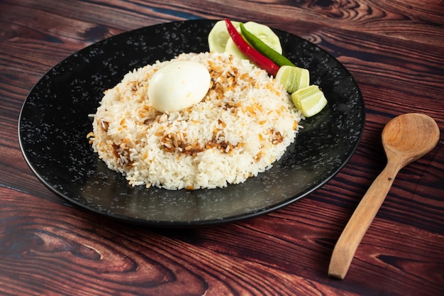 Spicy Egg pulao polao biryani mandi kacchi with egg and salad served in dish isolated on table top view of indian food