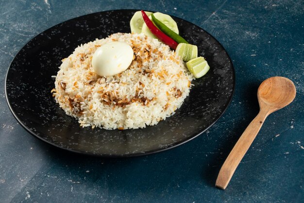 Spicy Egg pulao polao biryani mandi kacchi with egg and salad served in dish isolated on table top view of indian food