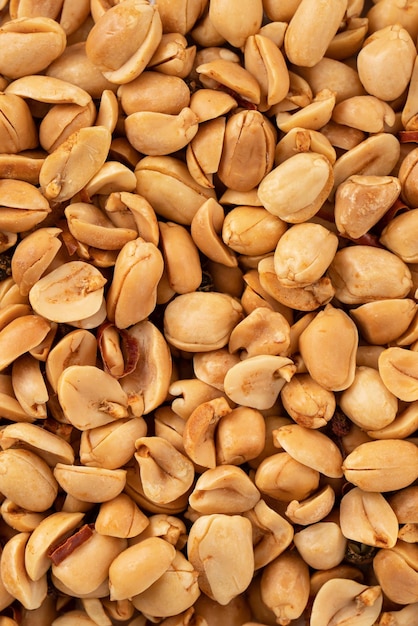 Spicy flavored peanut kernel spilling on white table background