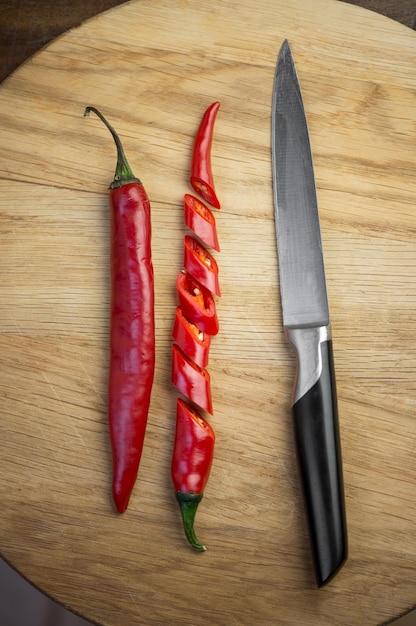 Spicy food Red chili pepper cut into pieces on a wooden board background Hot spice red chili pepper