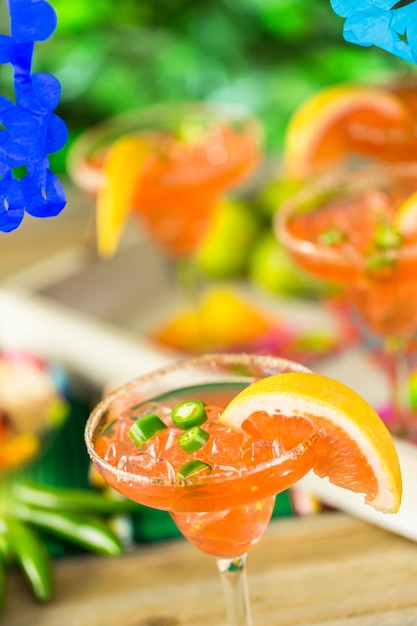 Spicy grapefruit margarita on ice in margarita glasses on the table in the garden.