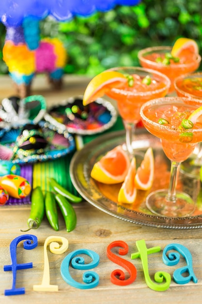 Spicy grapefruit margarita on ice in margarita glasses on the table in the garden.