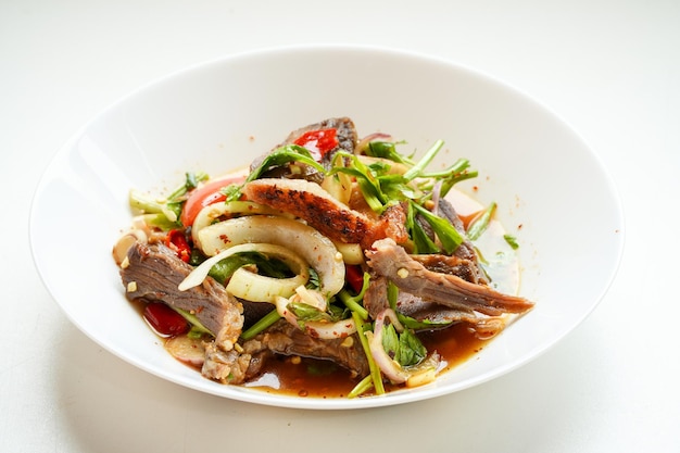 Spicy grilled beef salad in a white platefood concept