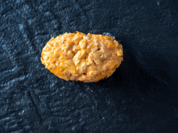 Spicy guncan with chicken and spicy sauce on a dark textured surface. Top view, lay flat