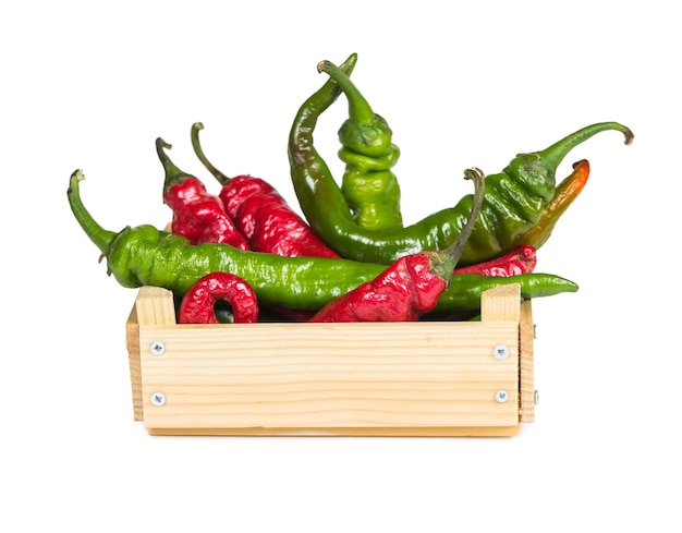 Spicy hot peppers in a wooden box isolated on white background