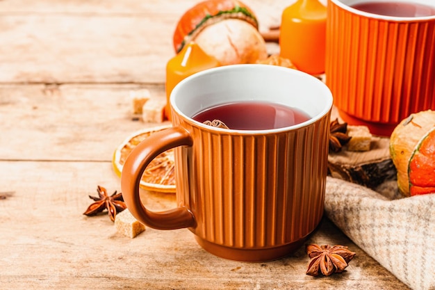 Foto tè caldo piccante autunno buon umore tradizionale bevanda autunnale in tazze candele sciarpa di zucca