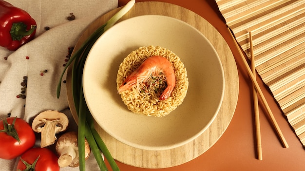 Spicy instant noodle soup with shrimp and vegetables. shrimp soup, cooking, food. Raw dried circle-shaped vermicelli in a plate. pasta, for the preparation of which it is enough to pour boiling water.