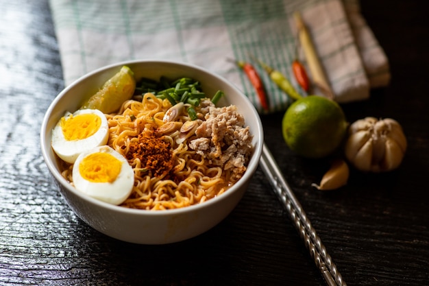 Spicy instant noodles soup with ingredient in bowl