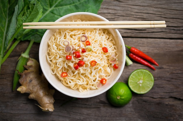 Spicy Instant noodles with Vegetable in a bowl on wood board.