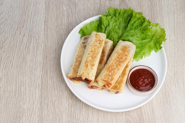 Spicy kebab with meat and mozzarella cheese served with lettuce and chilli sauce Selective focus