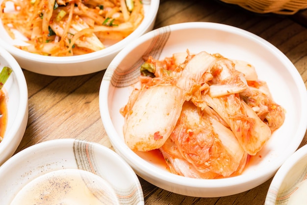 スパイシーなキムチ韓国の漬物または大根の漬物とボウルの調味料
