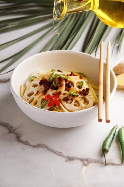 Spicy lotus root salad on the white stone background, asian food