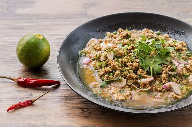 Spicy minced beef on wood table.