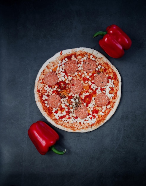 Spicy pepperoni pizza on a dark background. top view