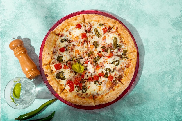 明るい灰色の背景の上面図にチキントマトとハラペーニョのスパイシーなピザ