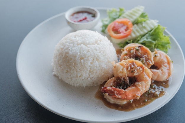 Фото Пикантные слоеные креветки с отварным рисом в блюде.