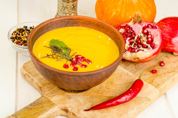 Spicy pumpkin carrot soup cream with pomegranate