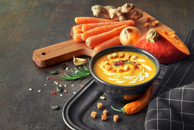 Spicy pumpkin soup with carrot, chili, ginger and garlic, space