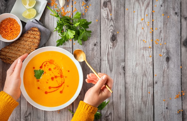 Spicy red lentil soup on gray wooden table