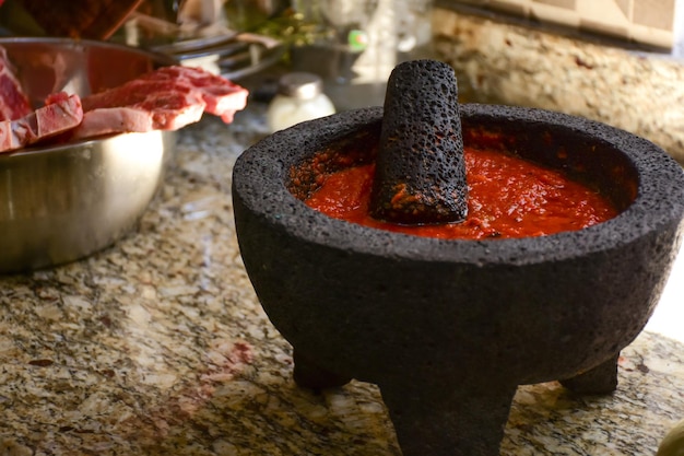 Spicy red sauce in a Traditional Mexican molcajete at kitchen